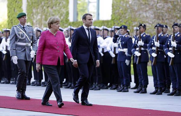 New French President Emmanuel Macron is welcomed by German Chancellor Angela Merkel with a military ceremony in Berlin Monday, May 15, 2017, during his first foreign trip after his inauguration the day before. (ANSA/AP Photo/Michael Sohn) [CopyrightNotice: Copyright 2017 The Associated Press. All rights reserved.]